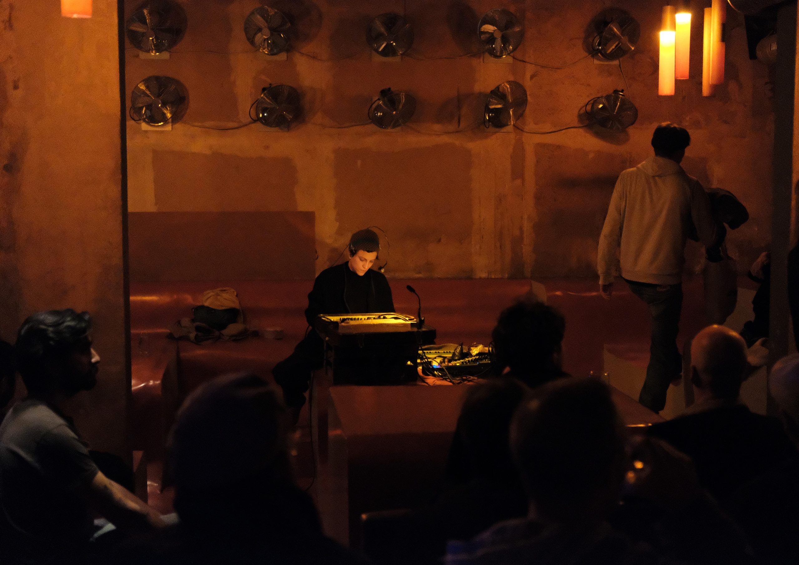 an image of the artist Diane Barbe seated in a venue with a microphone and music equipment